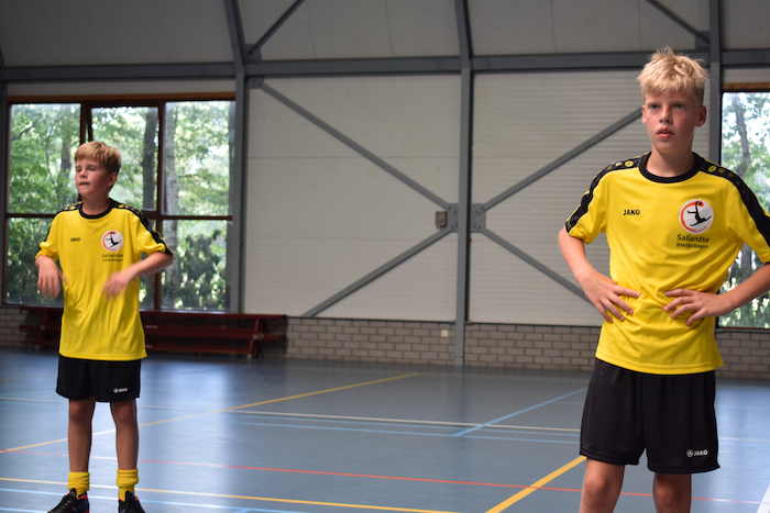 Twee jongens spelen zaalvoetbal op kamp in Nederland.