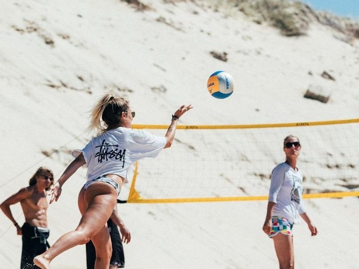 Jongeren spelen volleybal op kitesurfkamp Nederland.