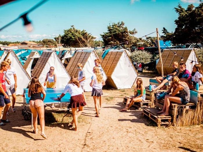 Jonge mensen spelen pingpong op het strand tijdens reis.