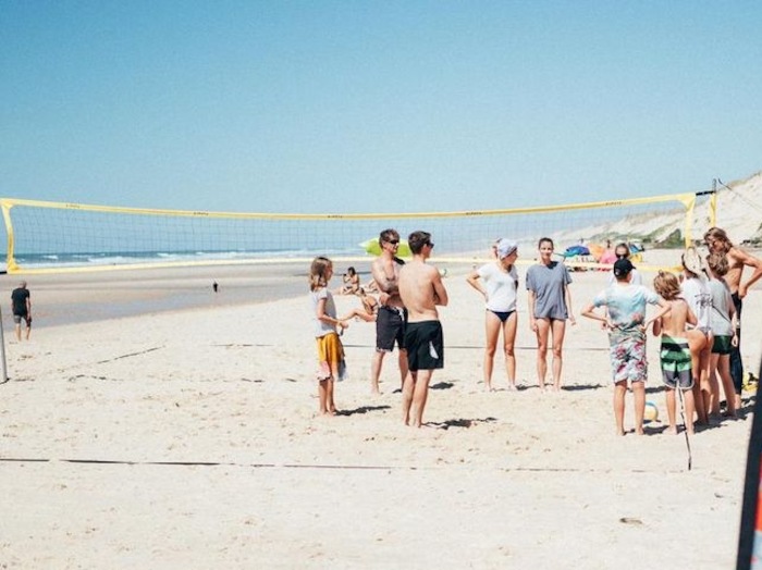 Op jongerenreis spelen jongeren beachvolley op het idyllische strand.