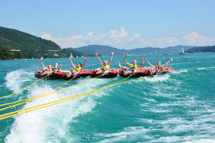 Kinder eines Sportcamps werden übers Wasser gezogen