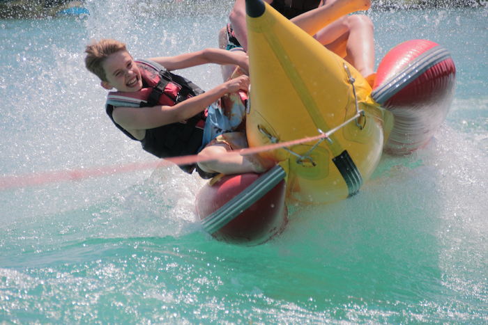 Kinder eines Sportcamps fahren Bananen-Boot