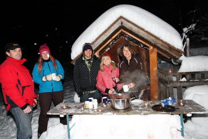 Teilnehmer eines Sportlagers grillen draußen
