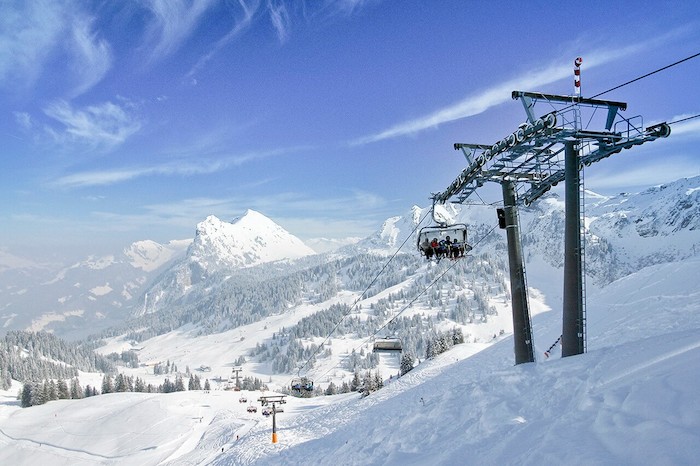 Teilnehmer eines Sportlagers fahren im Skilift