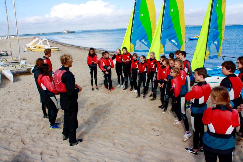 Teilnehmer bei Meerferien bei einem Surfkurs am Strand