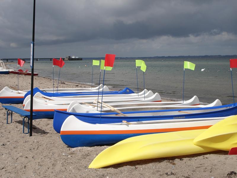 Kanus liegen bei Meerferien am Strand