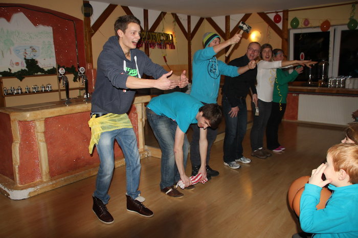 Teilnehmer der Skifreizeit spielen gemeinsam ein Spiel in der Hütte