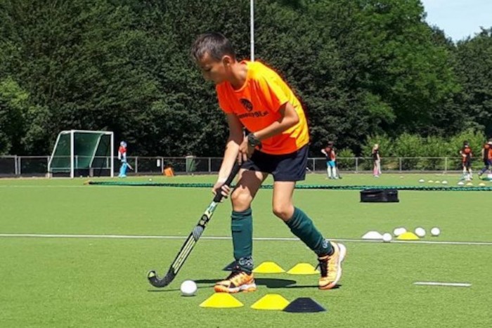 Ein Junge einer Kinderreise Holland dribbelt einen Ball