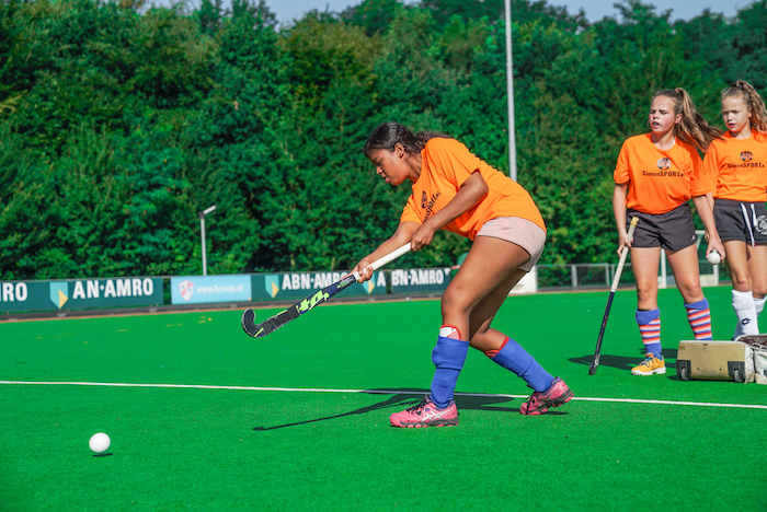 Ein Mädchen einer Kinderreise Holland spielt Hockey