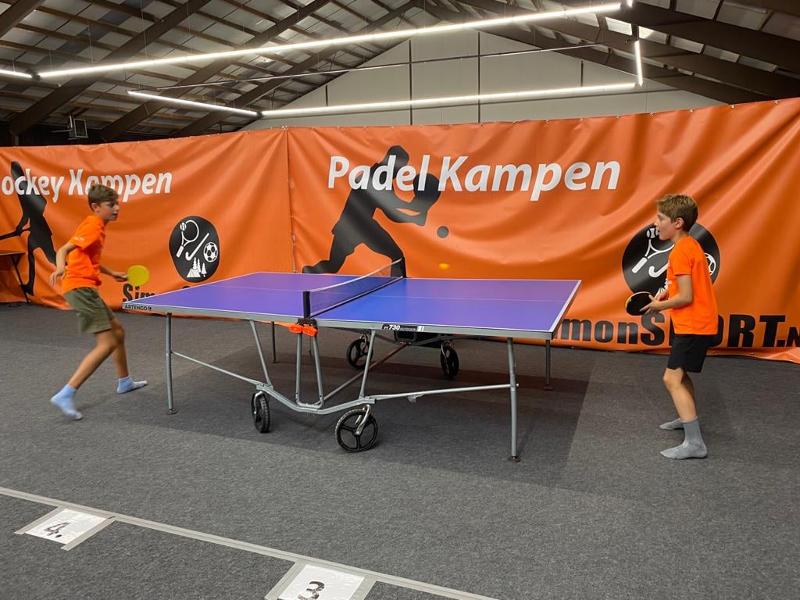 Zwei Jungs spielen im Tenniscamp gegeneinander
