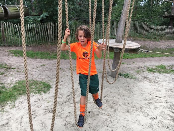 Ein Junge einer Kinderreise Holland ist im Niedrig-Seilgarten