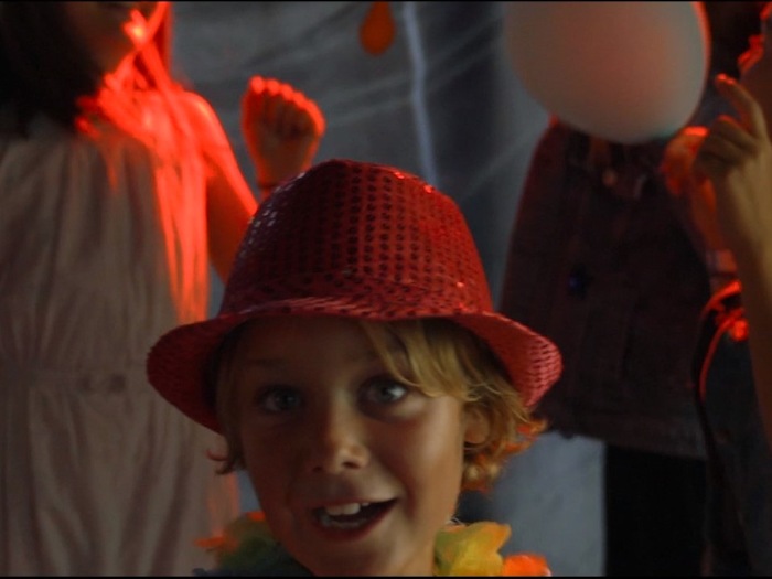 Ein Junge einer Kinderreise Holland hat einen Partyhut auf
