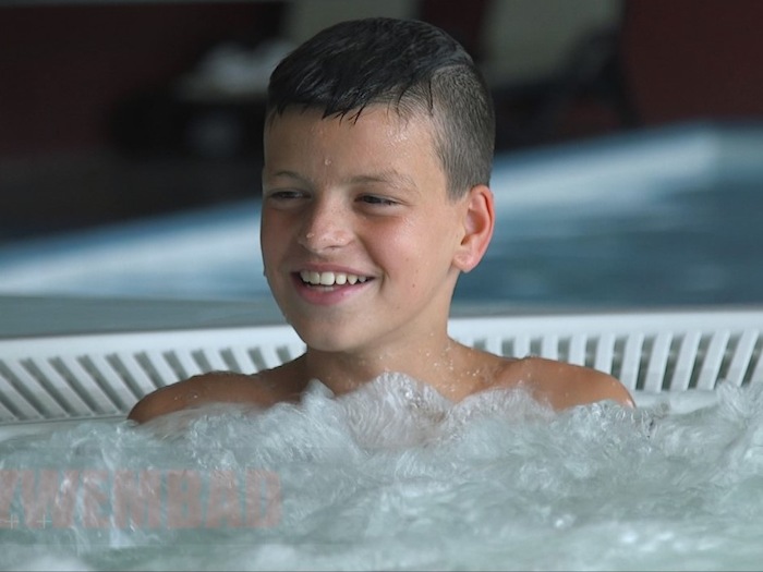 Ein Junge einer Kinderreise Holland sitzt im Whirlpool