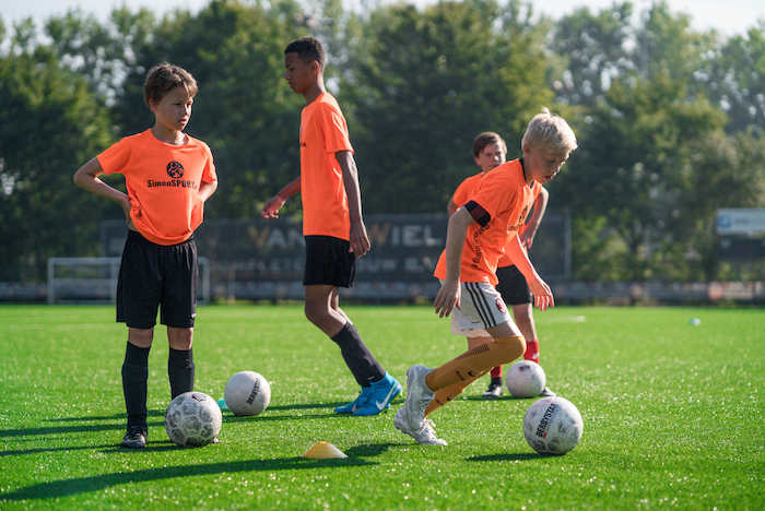 Kinder einer Kinderreise Holland spielen Fußball