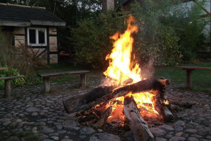 Kinder der Herbstferien Berlin sitzen am Lagerfeuer