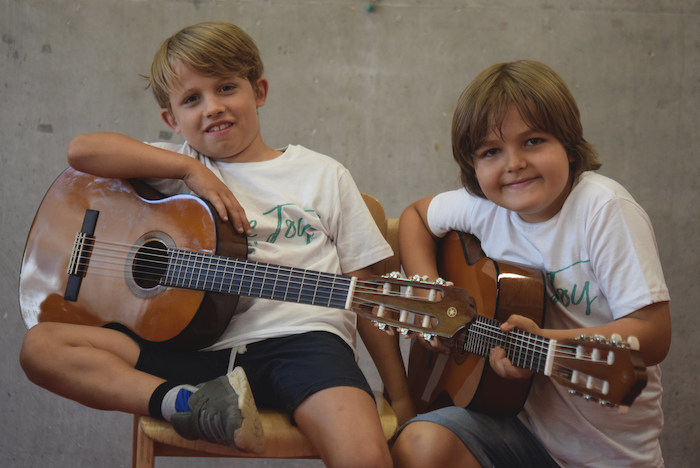 Zwei Teilnehmer im Feriencamp Düsseldorf spielen Gitarre