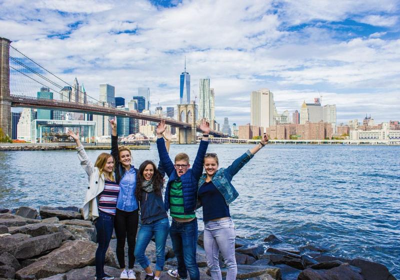  Eine Gruppe von Jugendlichen posiert mit der Stadt New York hinter sich für ein Gruppenfoto bei den Sprachreisen USA für Jugendliche