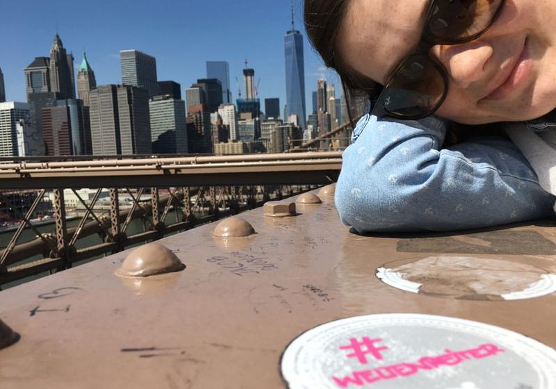 Eine Jugendliche macht ein Selfie von sich auf dem Dach eines Hochhauses, mit der Stadt New York im Hintergrund während unserer Sprachreisen USA für Jugendliche