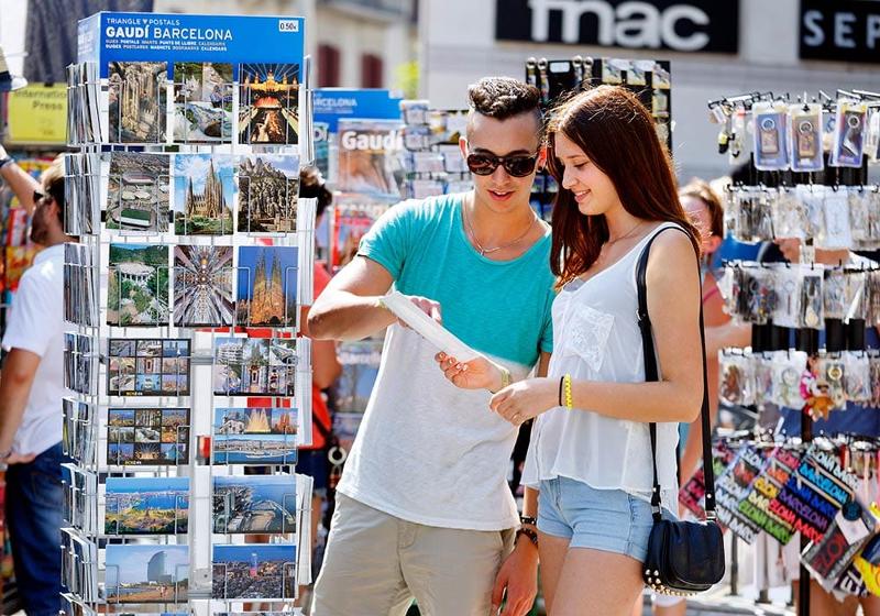 Teilnehmer einer Partyurlaub-Jugendreisen kaufen Postkarten