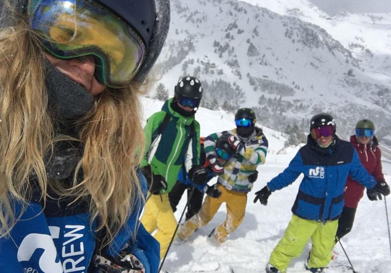 Teilnehmer einer Jugendreise ohne Eltern fahren im Tiefschnee Ski