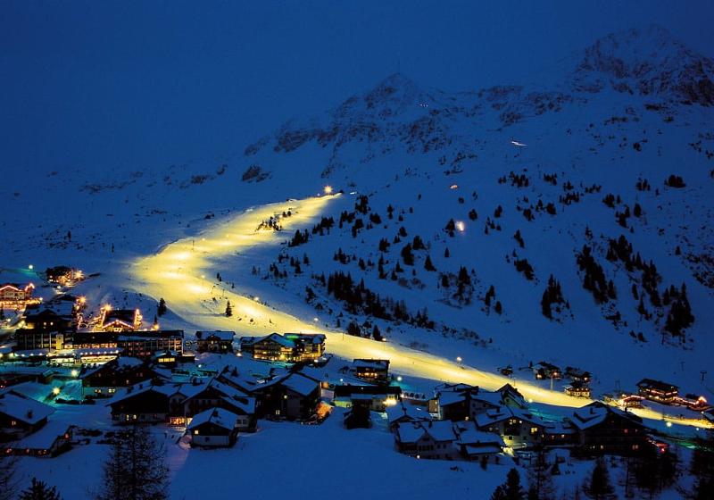 Teilnehmer einer Jugendreise ohne Eltern fahren nachts Ski