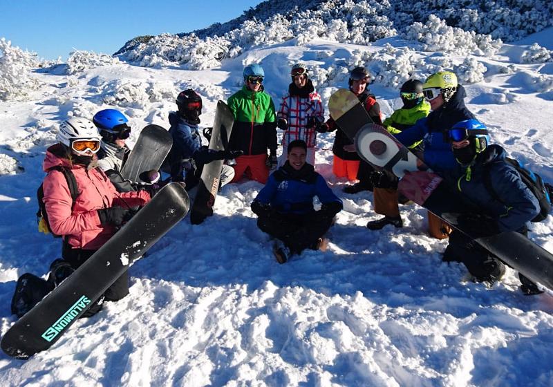 Teilnehmer einer Jugendreise ohne Eltern machen ein Gruppenfoto im Schnee