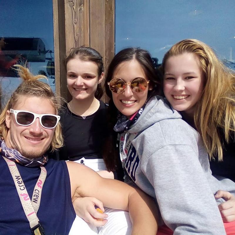 Teilnehmer einer Jugendreise ohne Eltern sitzen in der Sonne und machen ein Selfie