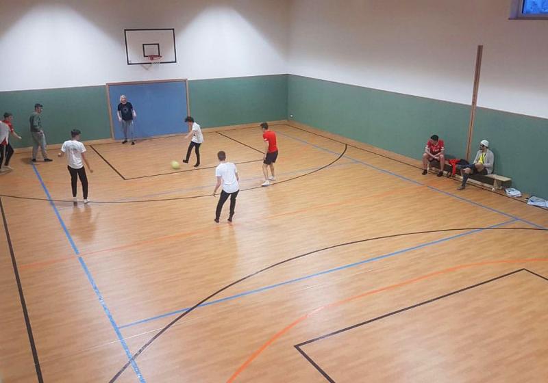 Teilnehmer einer Jugendreise ohne Eltern spielen in einer Halle