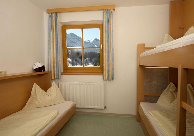 Teilnehmer einer Jugendreise ohne Eltern schlafen zu dritt in einem Zimmer