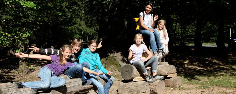 Eine Gruppe Kinder posiert im Ferienprogramm Heidelberg für ein Foto in einem Park