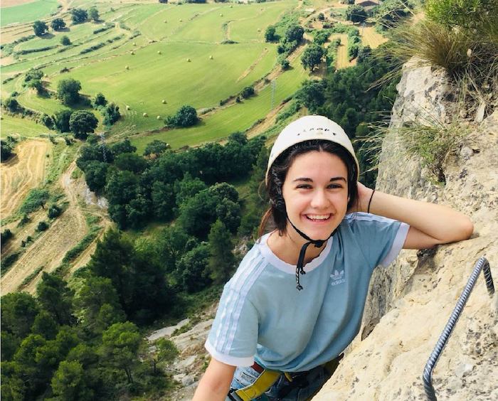 Jeune fille escalade une montagne en pleine nature lors d'une colo de vacances