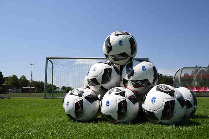 Mehrere Bälle eines Fußballcamps Mädchen liegen übereinander