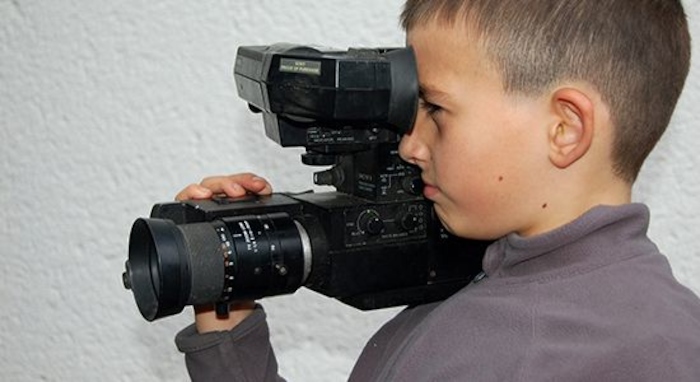 Enfant tient une caméra en colonie de vacances artistique