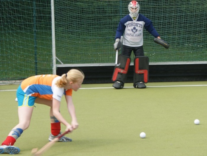 Ein Mädchen des Hockey-Camps schießt ein Tor