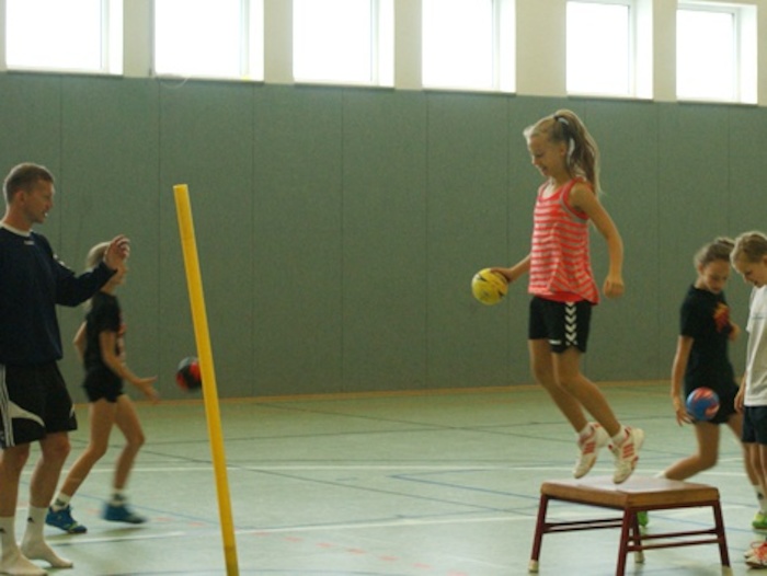 Ein Mädchen übt im Handball-Feriencamp werfen