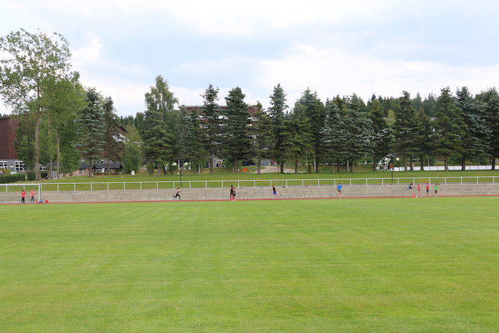 Während der Ferienbetreuung laufen die Kinder um einen Sportplatz