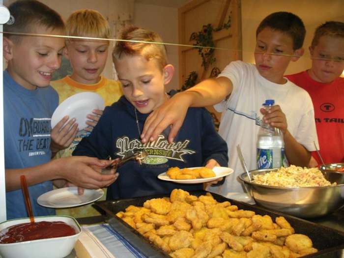 Kinder des Hockey-Camps essen Chicken Nuggets