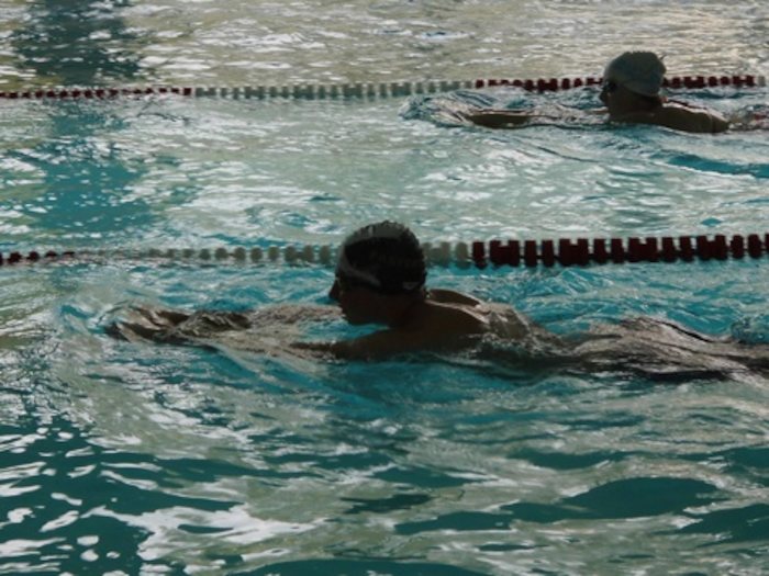 Ein Junge schwimmt eine Bahn entlang während der Ferienbetreuung
