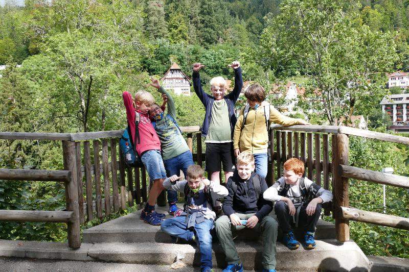 Im Ferienprogramm Darmstadt stehen ein paar Kinder während eines Ausflugs mitten in der Natur zusammen 