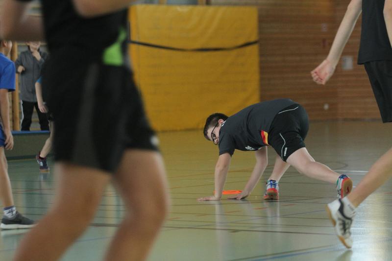 Ein Junge stützt sich auf dem Boden im Tischtennis Camp