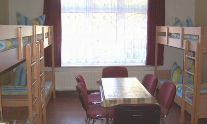 Teilnehmer eines Feriencamps für Kinder sitzen zusammen im Zimmer