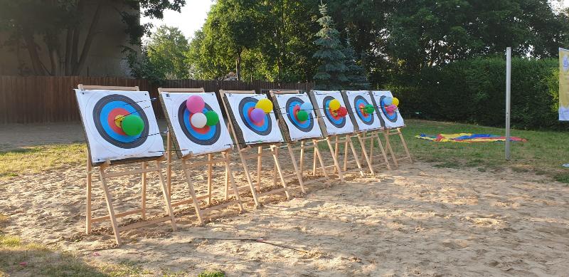 Kinder eines Feriencamps am Wasser spielen Schießen