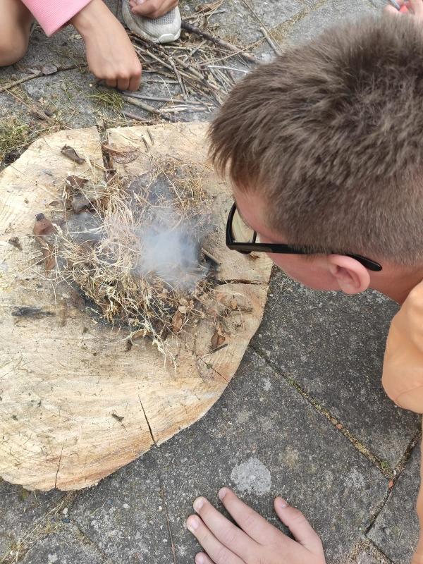 Kinder eines Feriencamps am Wasser machen Feuer