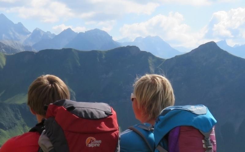 Zwei Kinder einer Jugendreisen alleine stehen vor dem Berg-Horizont