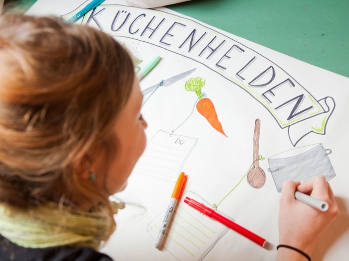 Teilnehmer einer Kinder Jugendfreizeit malen Plakate