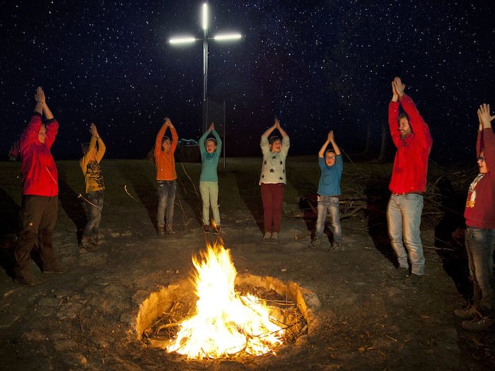Teilnehmer einer Kinder Jugendfreizeit tanzen am Lagerfeuer
