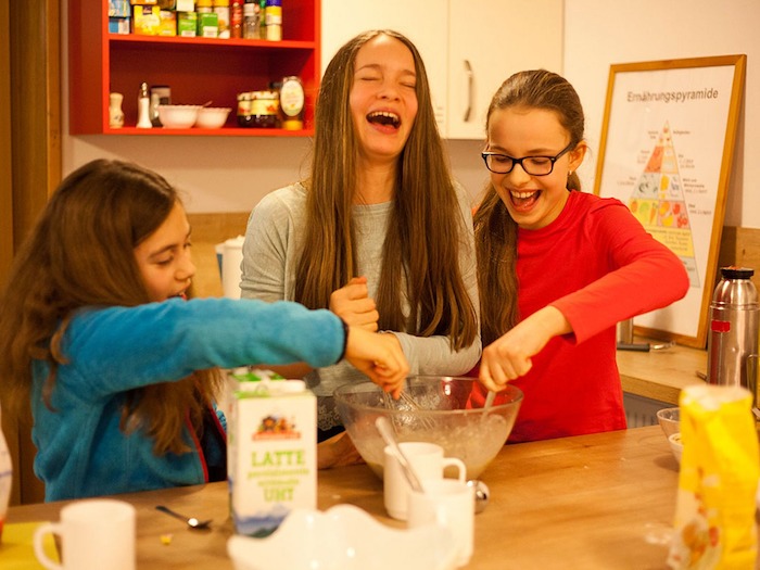 Teilnehmer eines Kinder und Jugendcamps backen zusammen