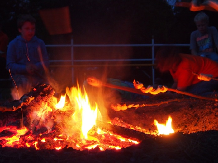 Teilnehmer einer Kinder und Jugendfreizeit machen Feuer