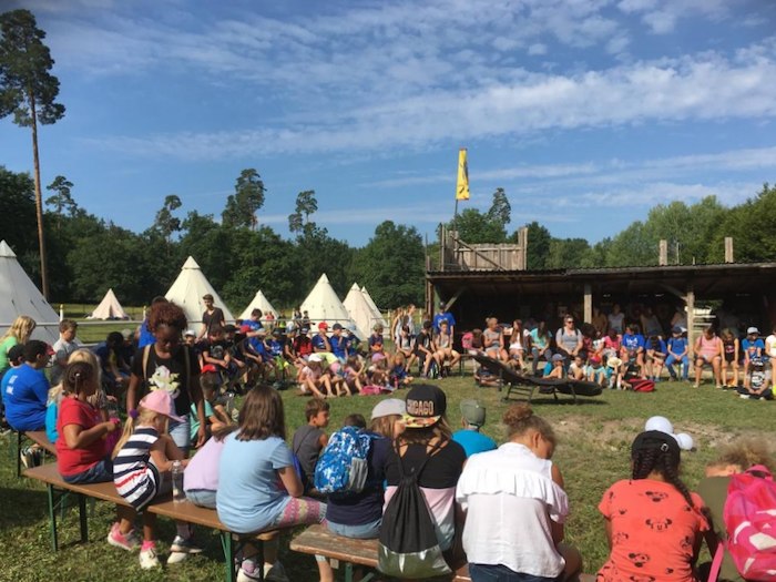 Teilnehmer einer Kinder und Jugendfreizeit sitzen zusammen in der Gruppe
