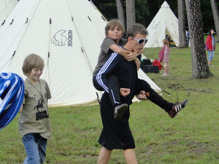 Teilnehmer einer Kinder und Jugendfreizeit tragen sich Huckepack